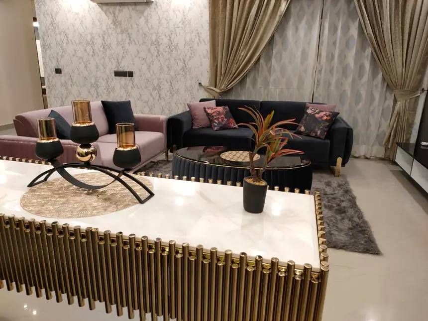 Living room with a gold fluted console, marble top and two sofas